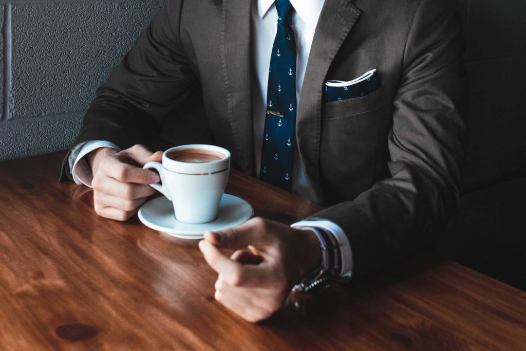 Photo of businessman holding cup of coffee.